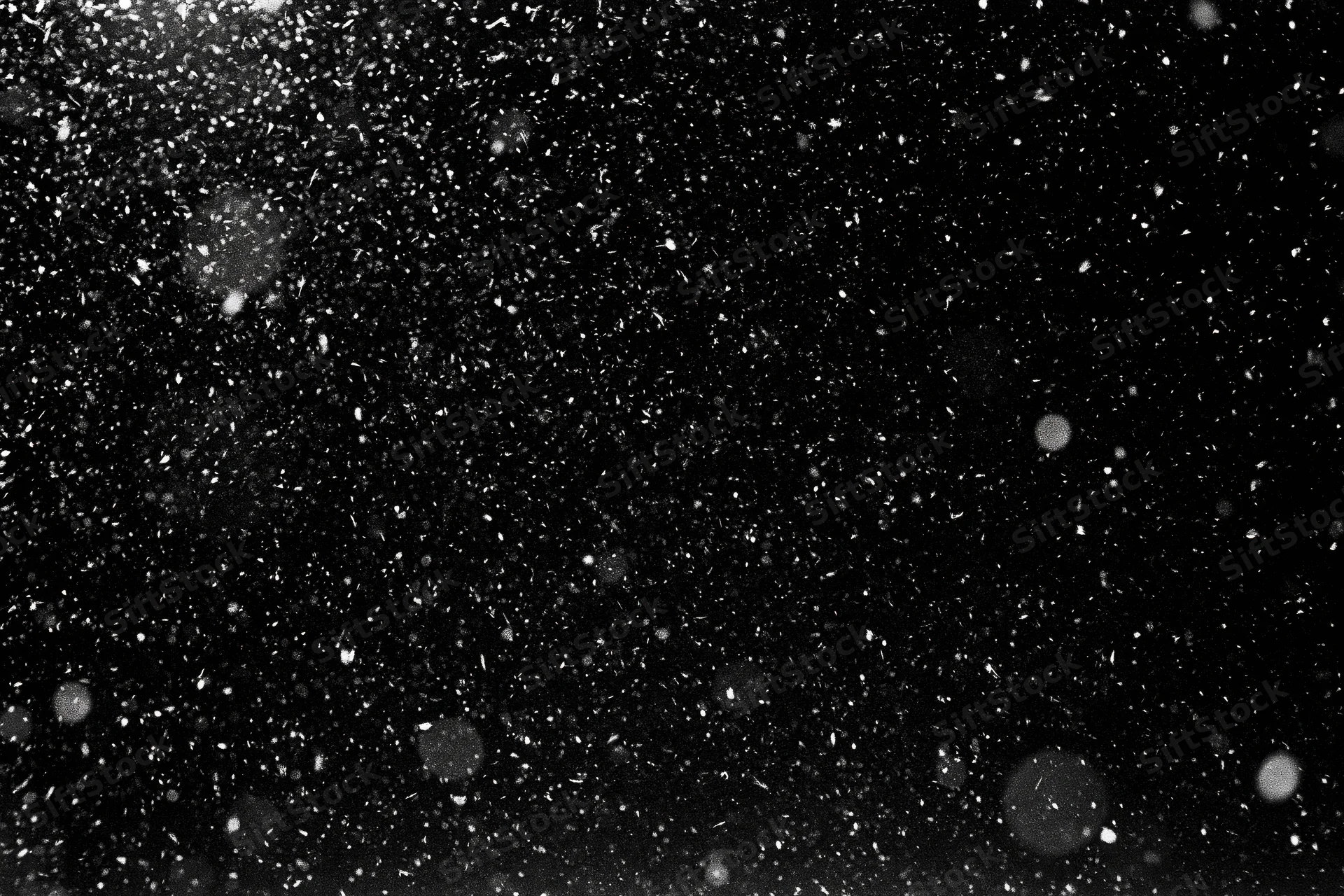Snow falling densely against a black night sky