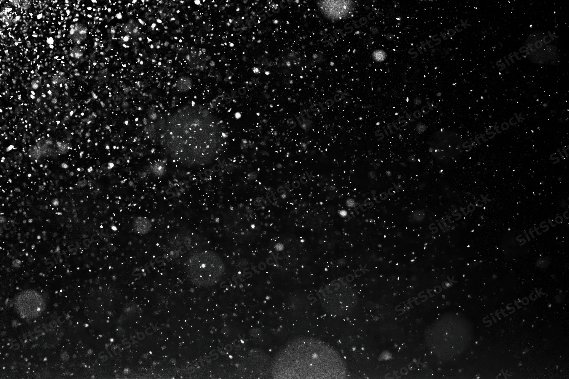 Snow falling densely against a black night sky