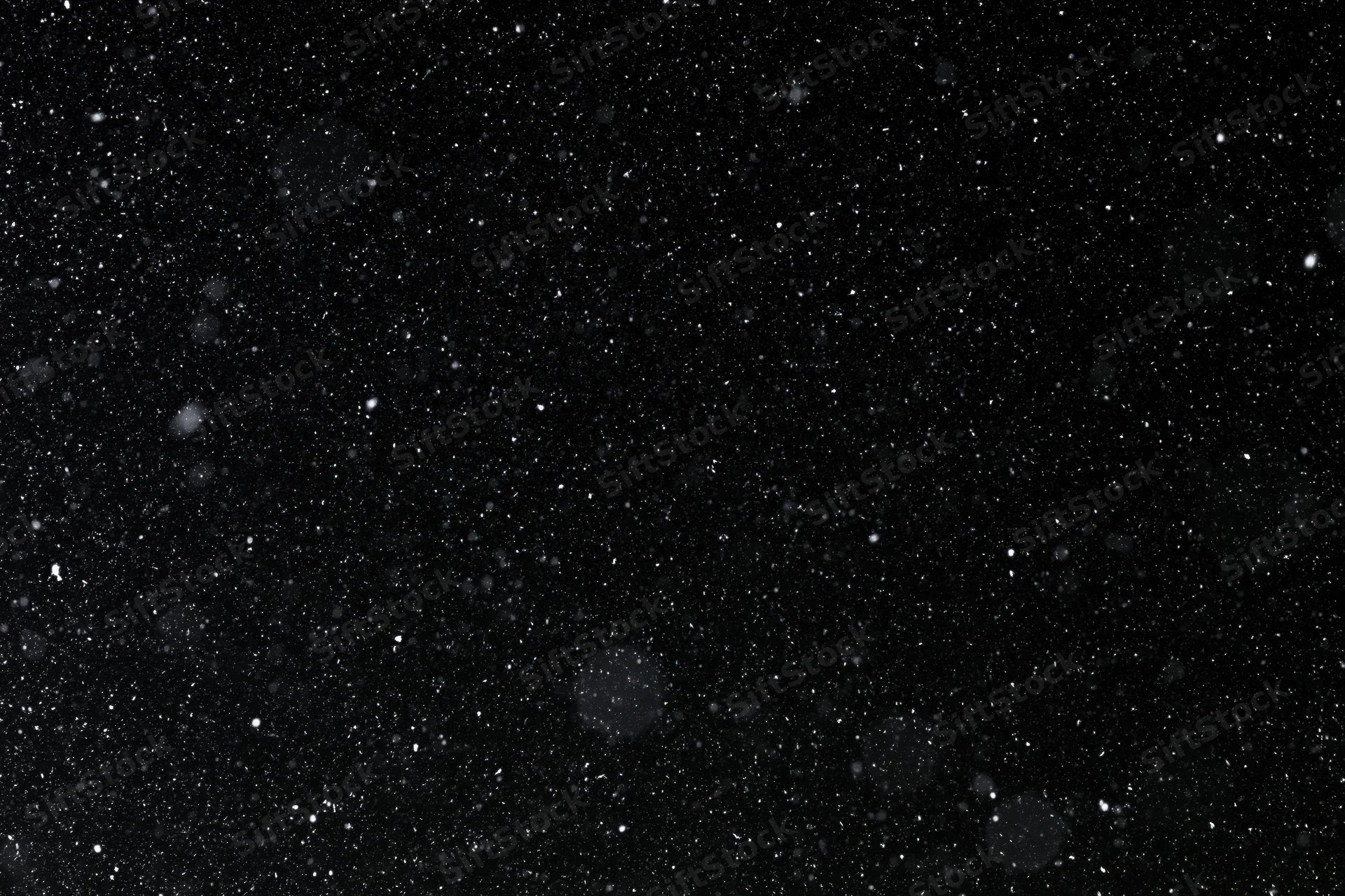 Heavy snowfall falling against a pure black night sky