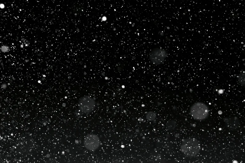 Heavy snowfall falling against a black night sky