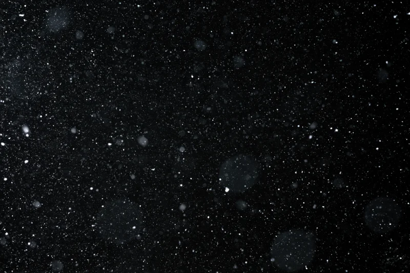 Heavy snowfall falling against a black night sky
