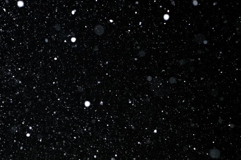Heavy snowfall falling against a pure black night sky