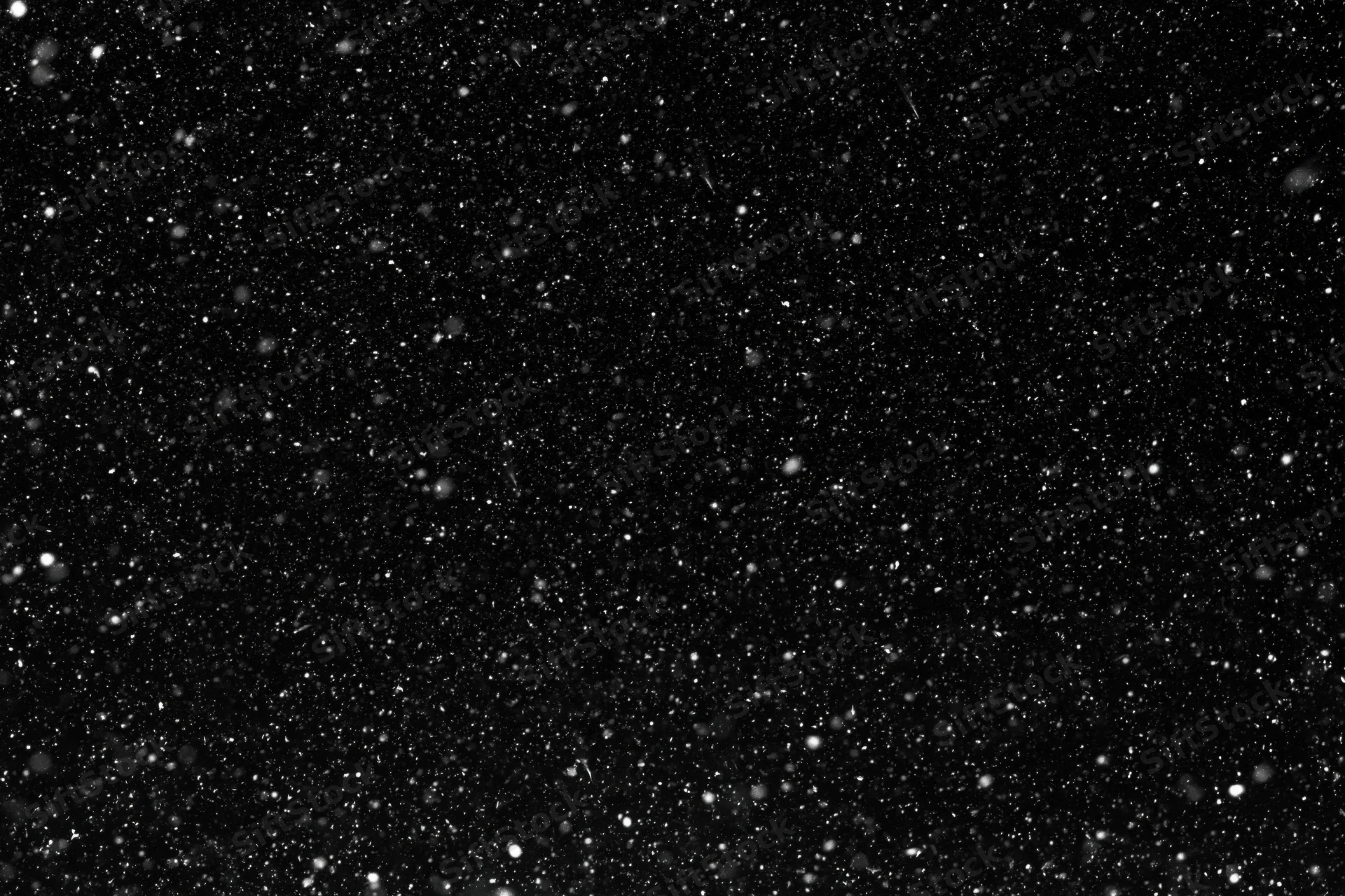 Heavy snowfall falling against a pure black night sky
