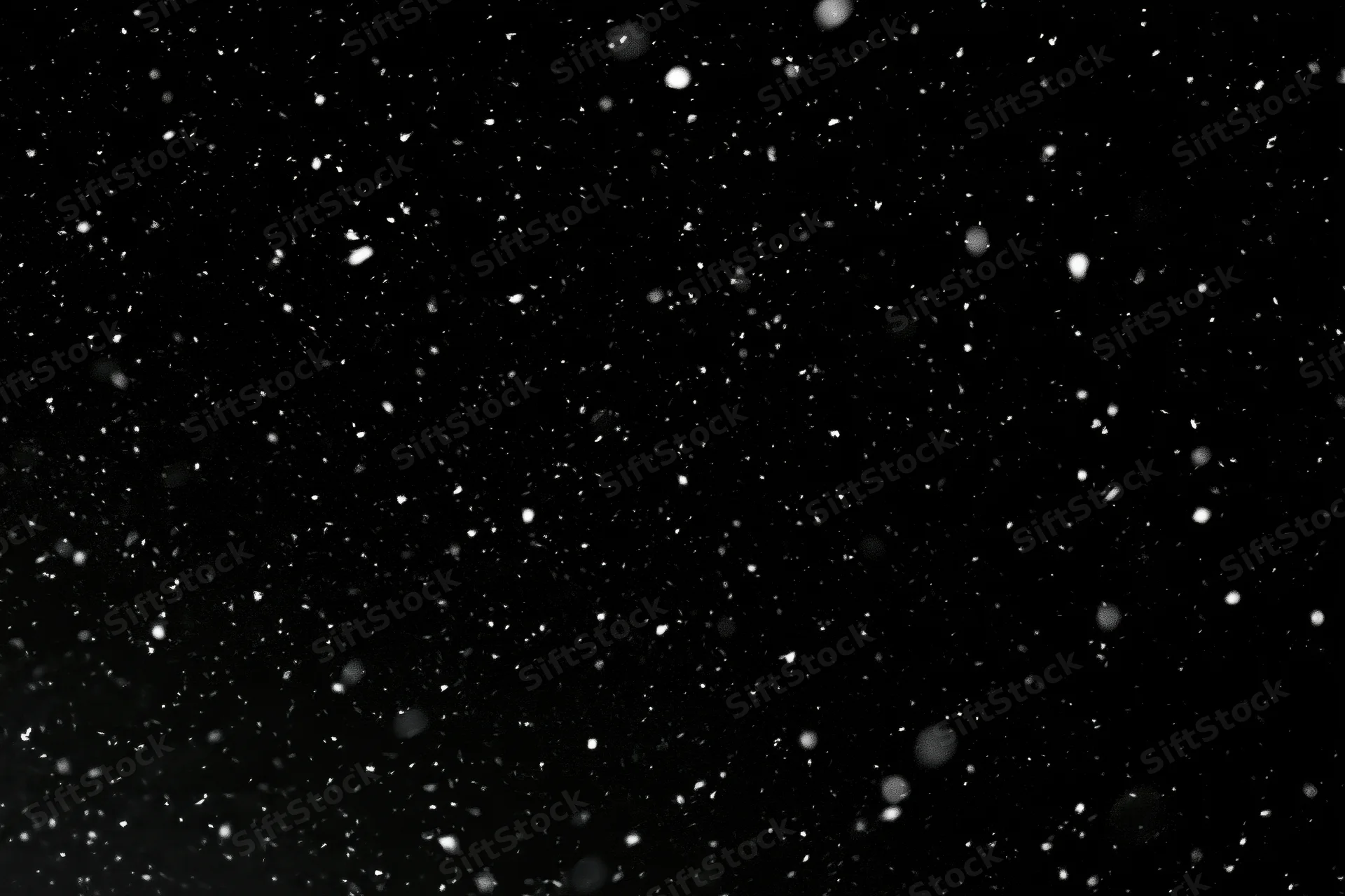 Snow falling against a black night sky