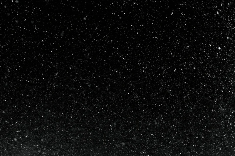 Heavy snowfall falling against a black night sky