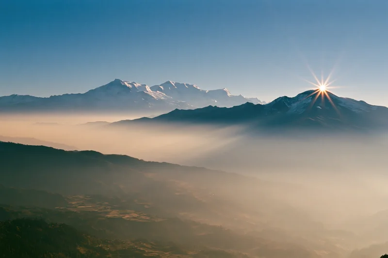 Snow-capped Himalayan peaks rising above a sea of fog at sunrise