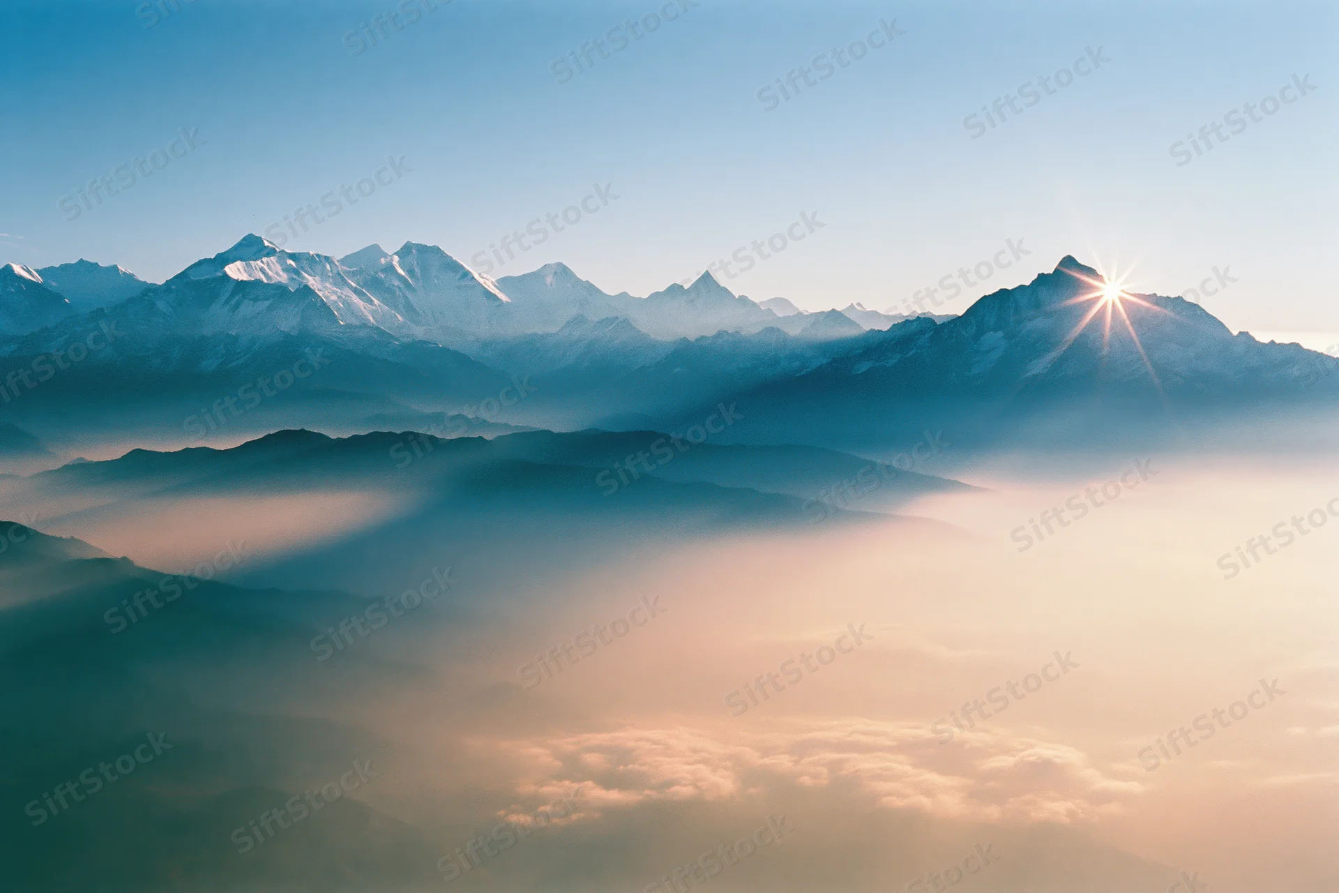Snow-capped himalayan peaks rising above a sea of fog at sunrise