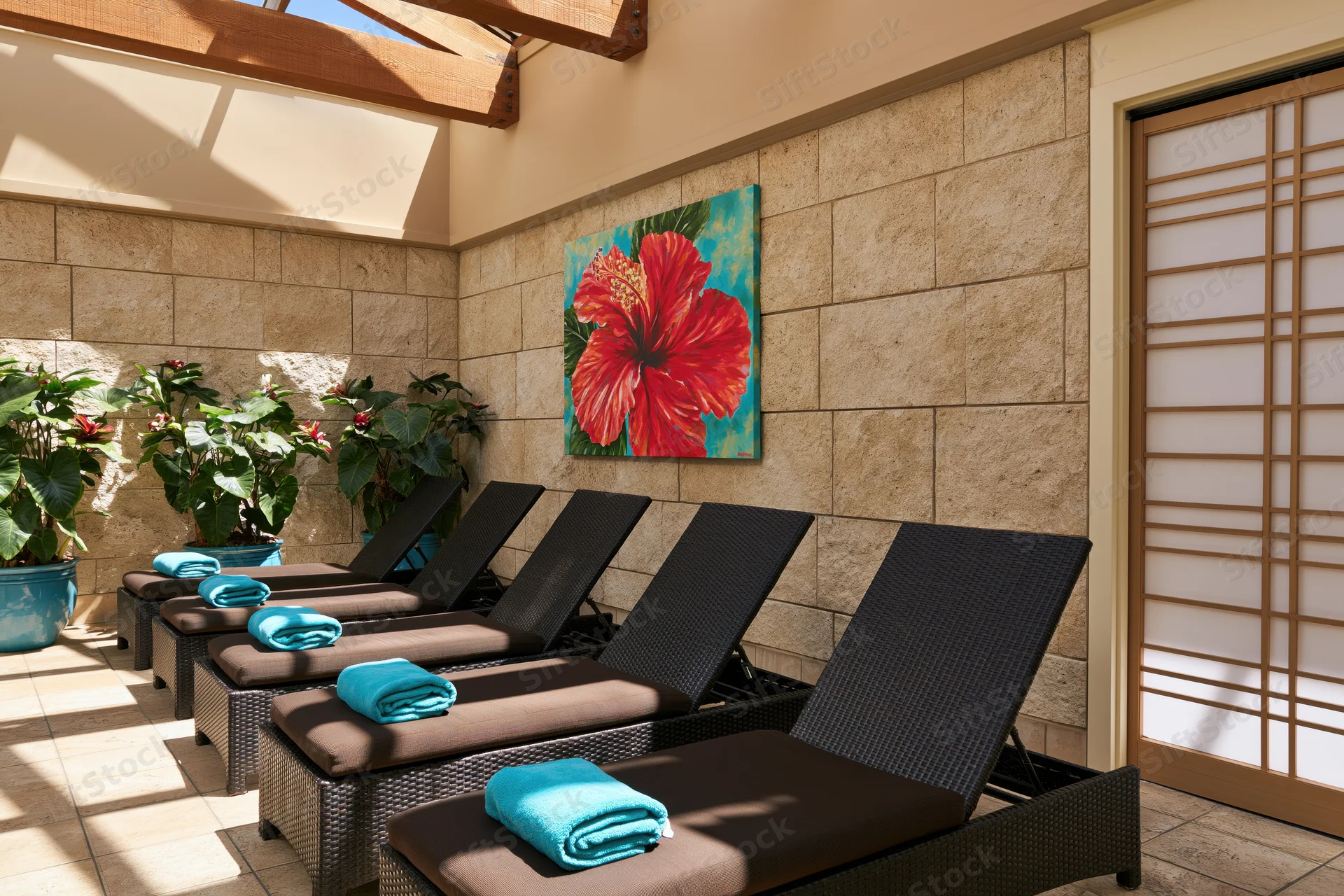 Dark wicker lounge chairs with blue towels arranged in a stone-walled spa patio under a skylight