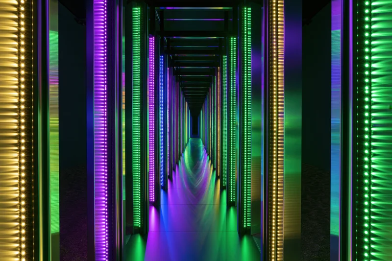 Illuminated corridor with vertical led strips in colorful pattern creating immersive tunnel effect