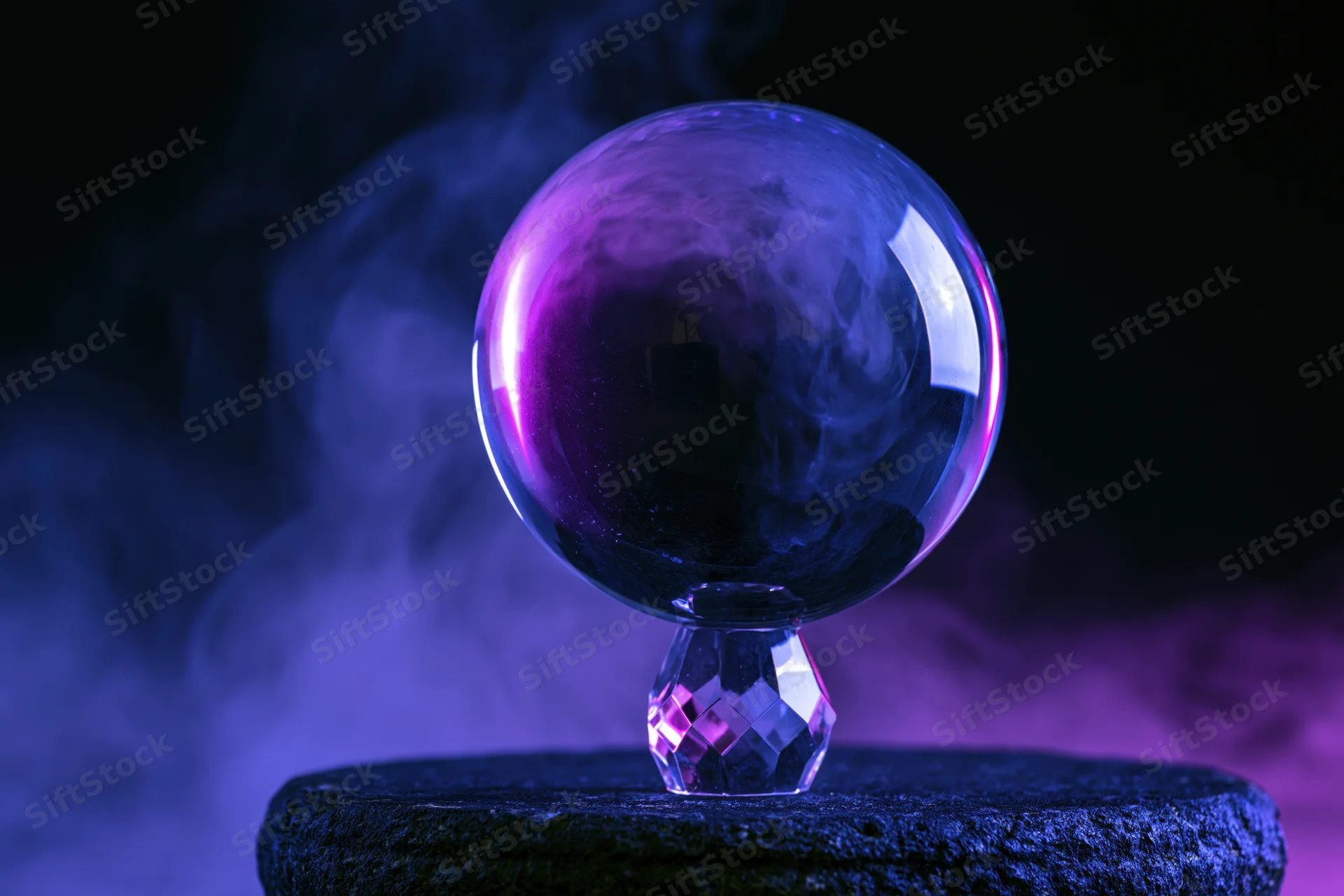 Crystal ball glowing with purple light and smoke on a dark stone base