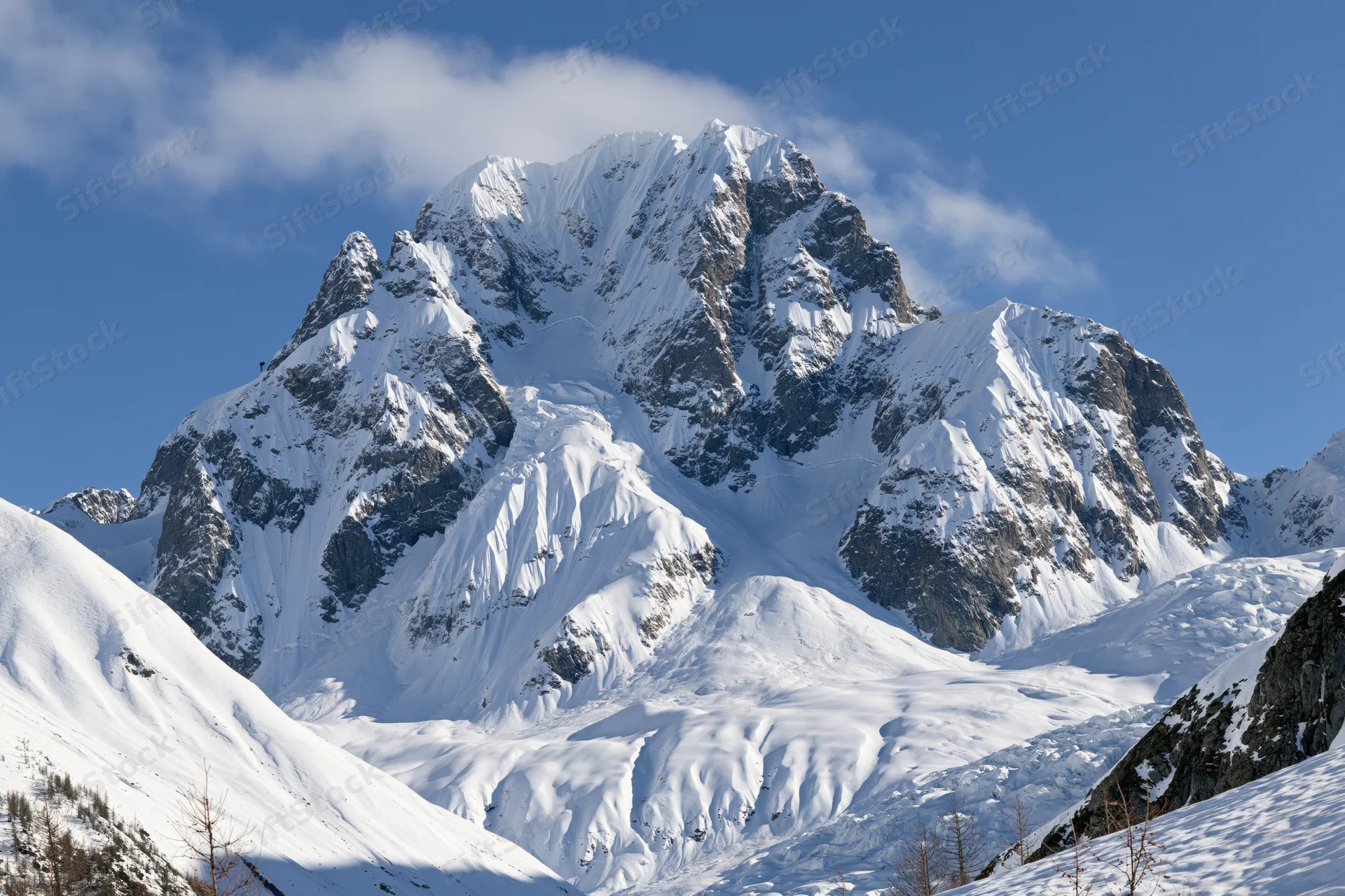 Snow-covered mountain peak rising against a clear blue sky in a winter alpine landscape