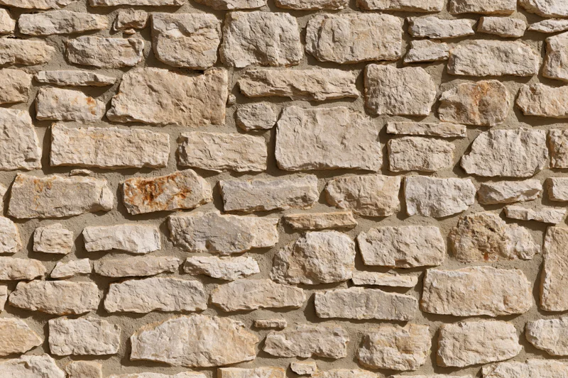 Old rustic stone wall filling the frame with natural weathered texture