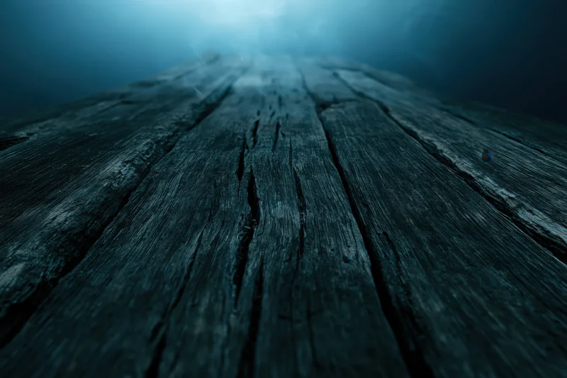 Weathered wooden planks stretching into dark underwater depths