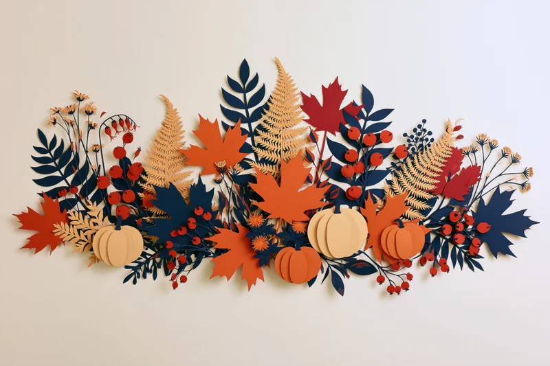 Paper-cut autumn botanical arrangement with maple leaves, pumpkins and ferns on flat surface