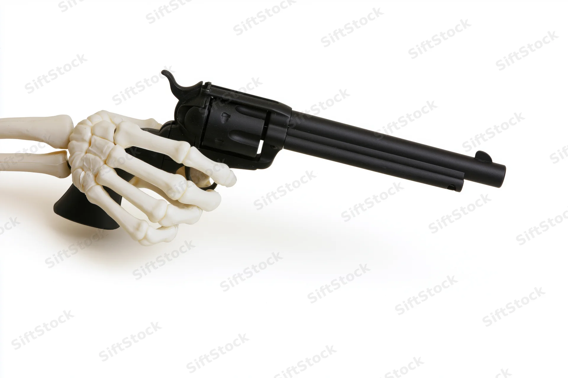 Skeleton hand gripping a black revolver on white background