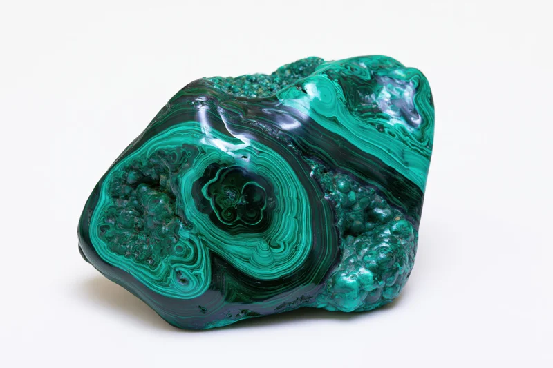 Polished malachite-chrysocolla mineral specimen with banded green and blue patterns on white background