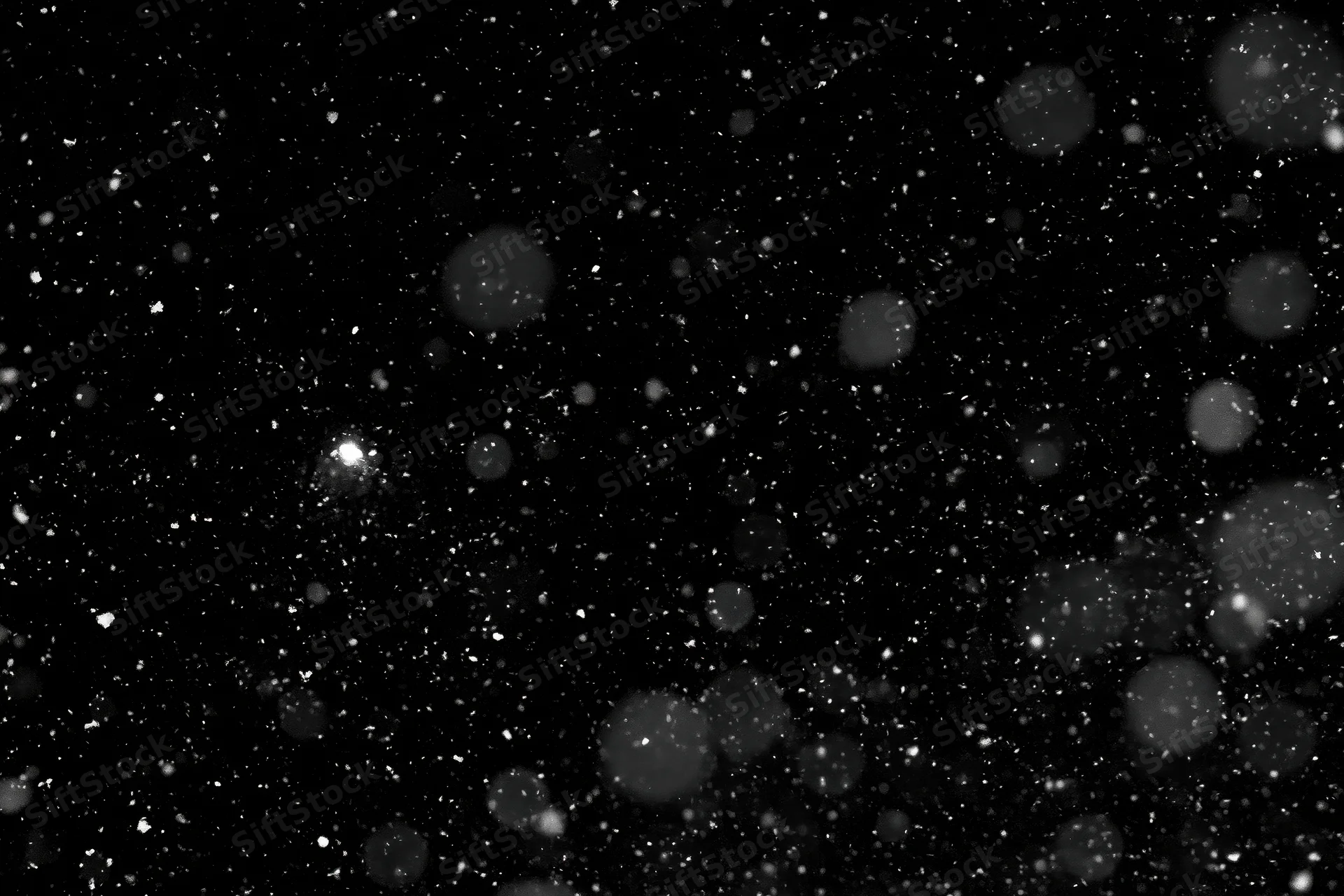 Snow falling against a black night sky