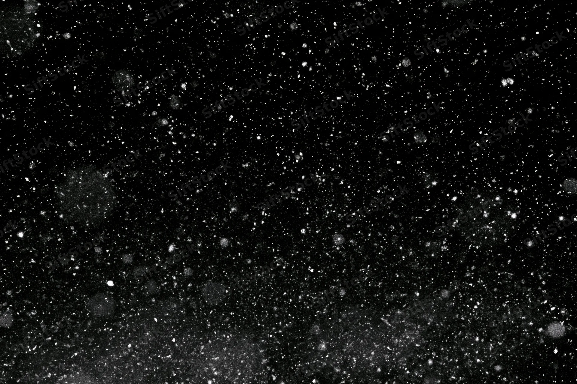 Snowflakes falling against a black night sky