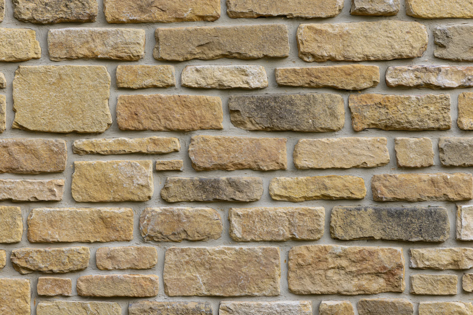 Rough-cut sandstone wall filling the frame with irregular stones and mortar joints