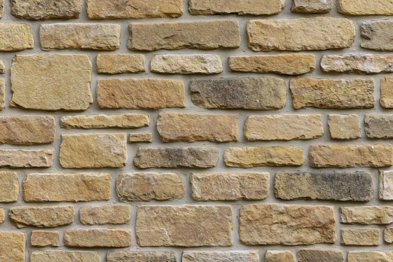 Rough-cut sandstone wall filling the frame with irregular stones and mortar joints