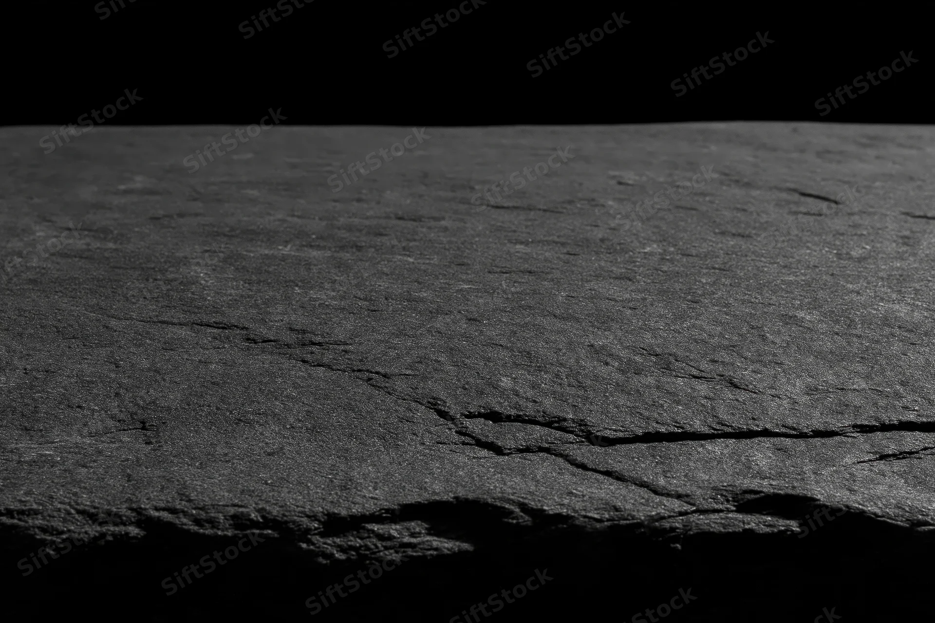 Cracked stone surface with rough texture for product display against black background