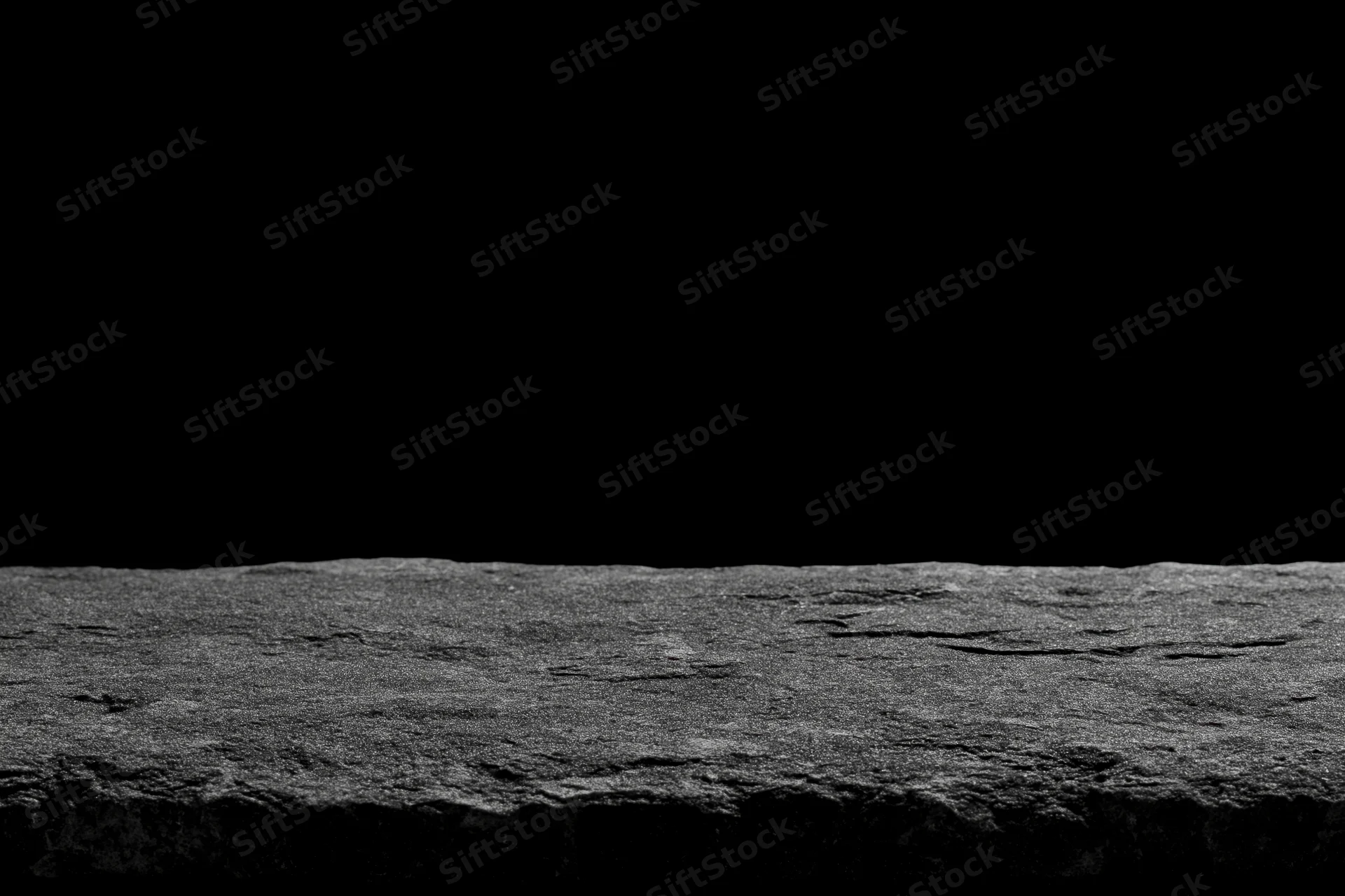 Rough cracked stone surface as product display platform against black background