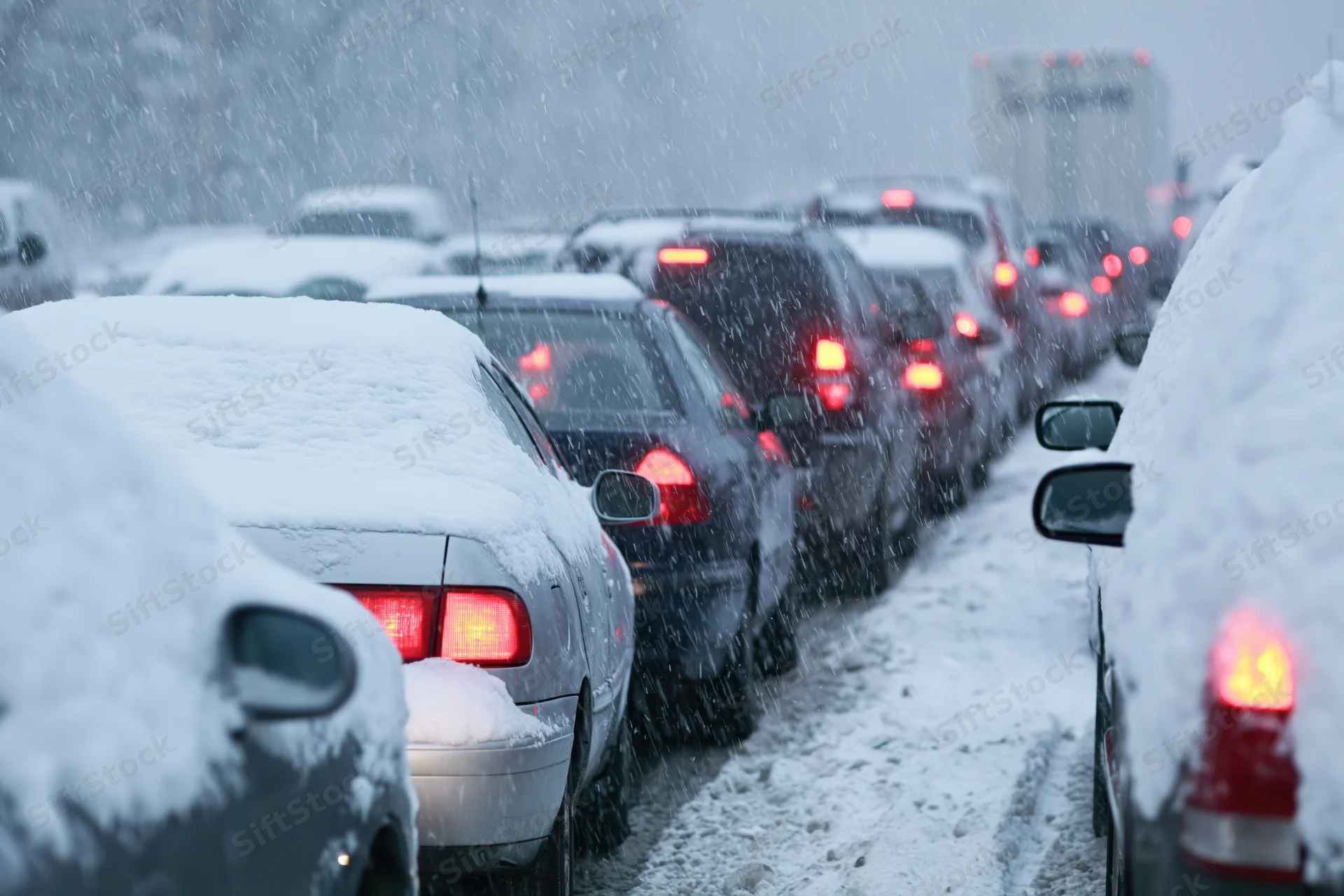 Row of cars stopped in heavy snowstorm traffic on a winter road