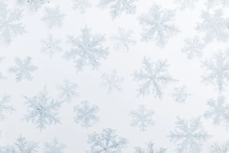 Scattered snowflakes floating on a white background