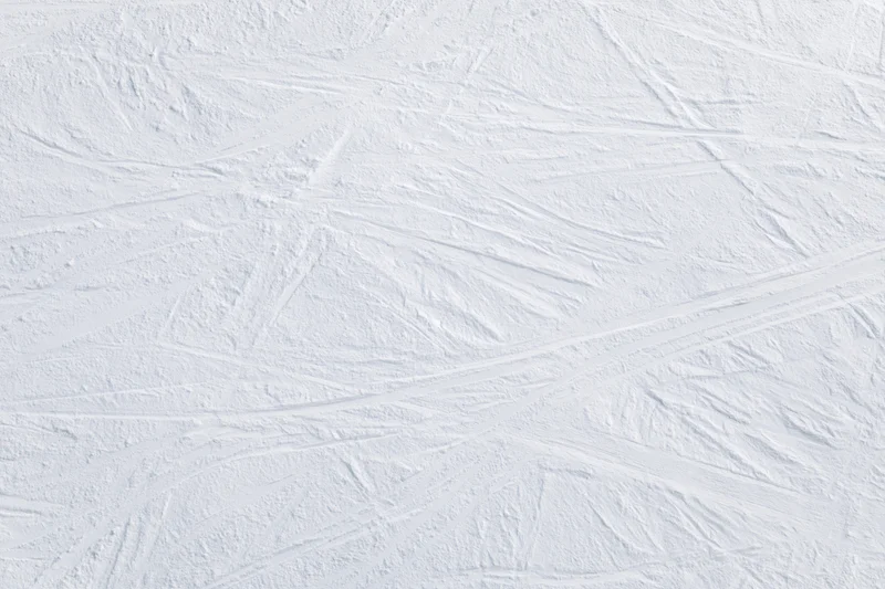 Ski slope surface with overlapping ski tracks and carving marks