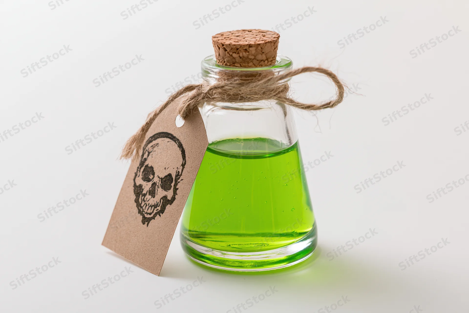 Small glass bottle filled with bright green liquid and skull tag on white background
