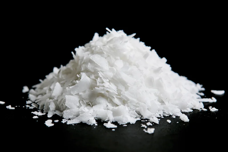 Pile of white coconut flakes on black background