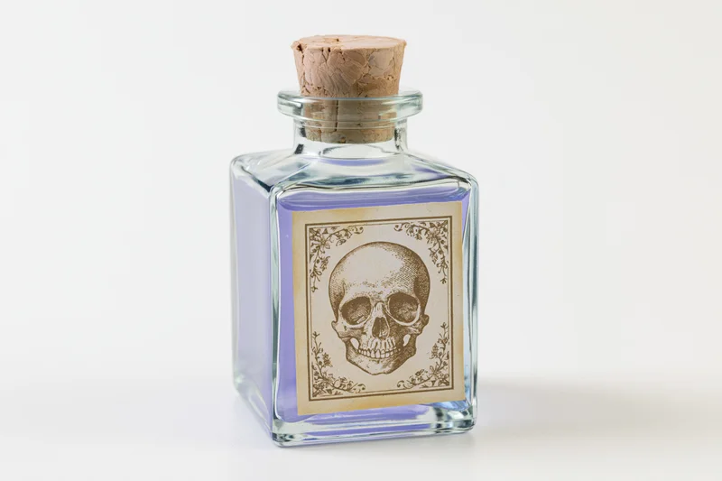 Square glass apothecary bottle with skull label and lavender liquid, cork stopper, on white background
