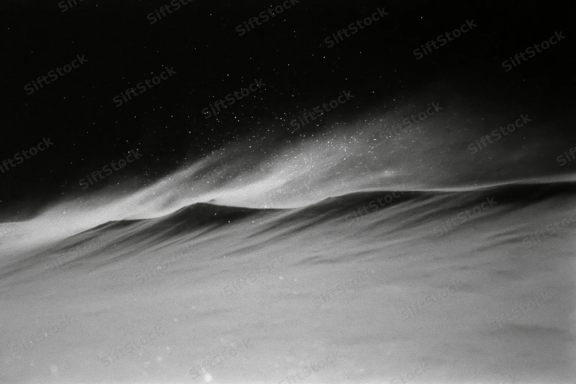 Snow blowing across a high alpine ridge at night under a starry sky