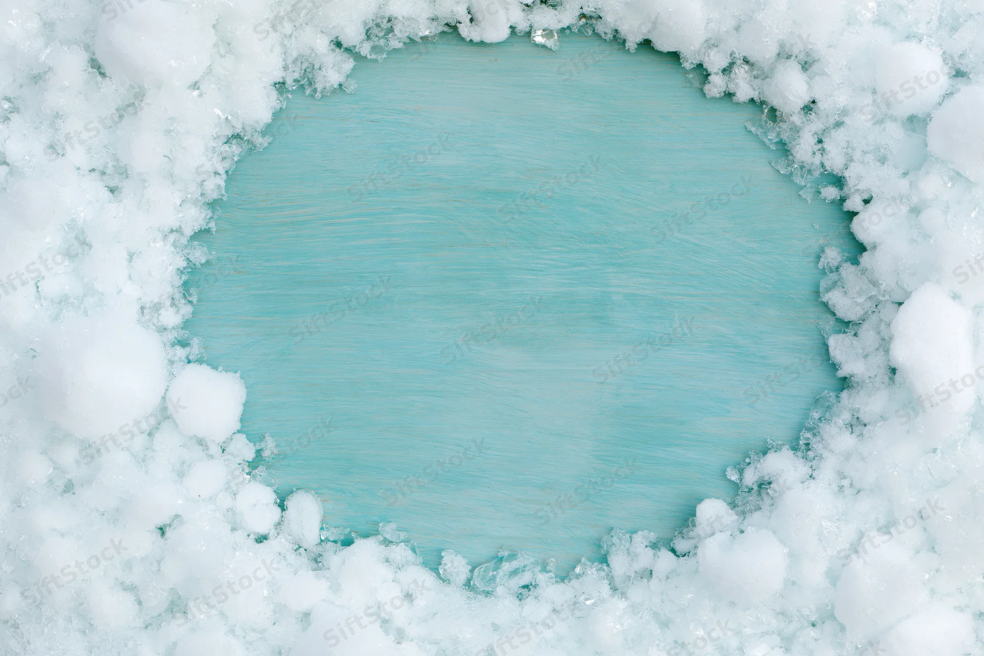 Snow cleared in a rough circle revealing a painted turquoise wooden surface