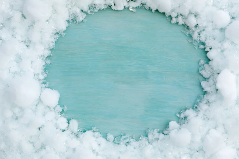 Snow cleared in a rough circle revealing a painted turquoise wooden surface
