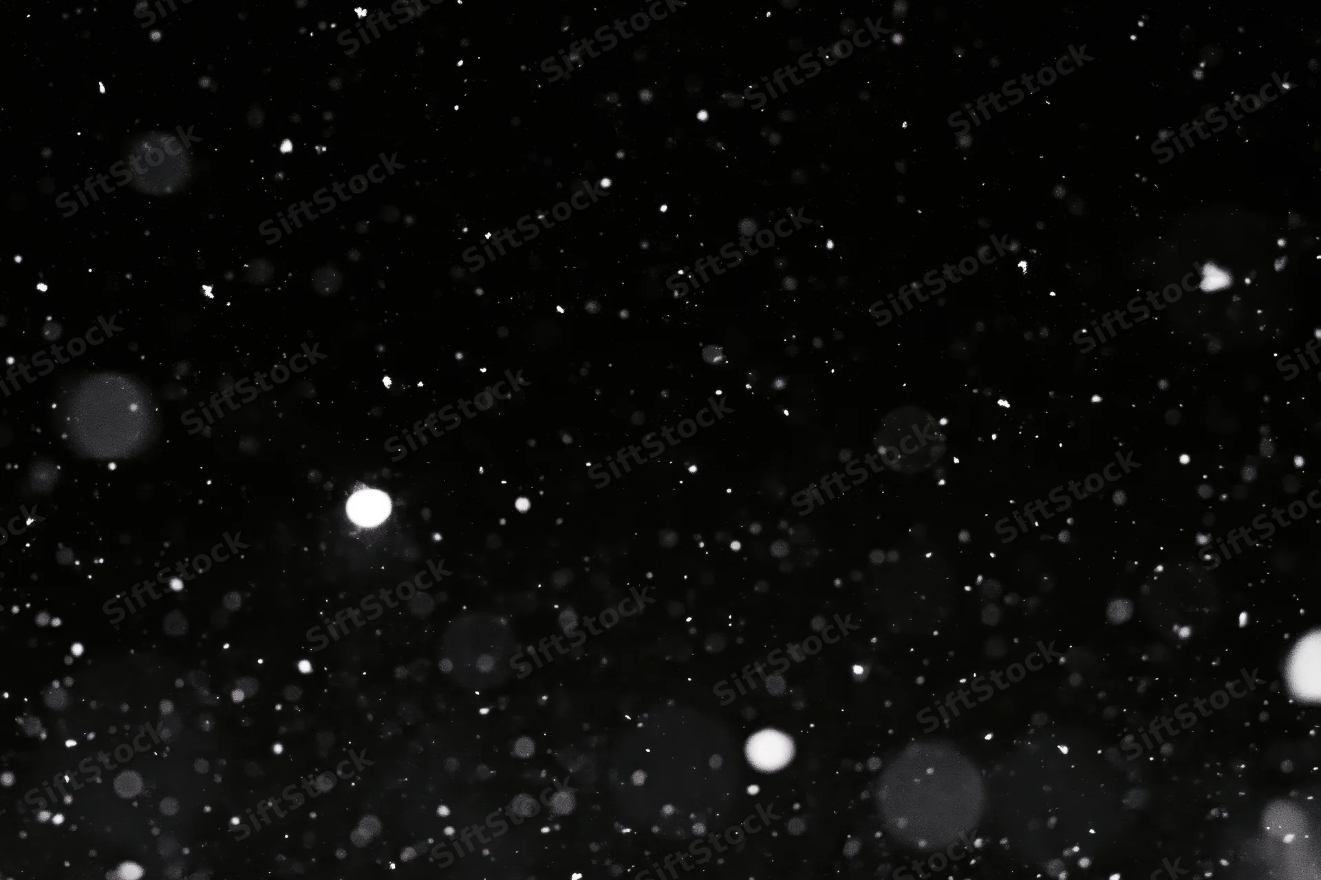 Snow falling against a black night sky