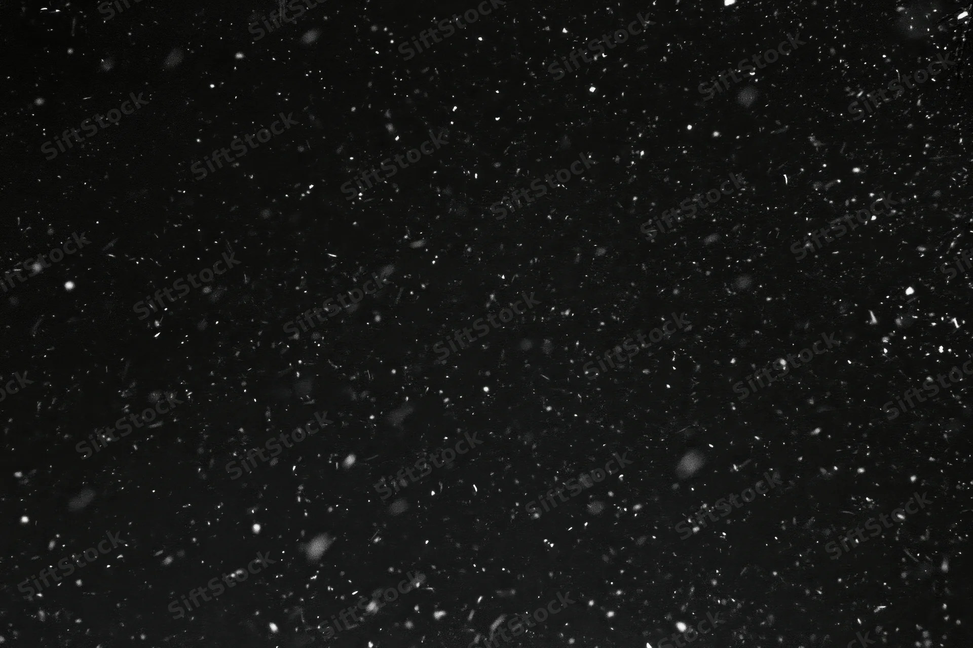 Snow falling against a black night sky