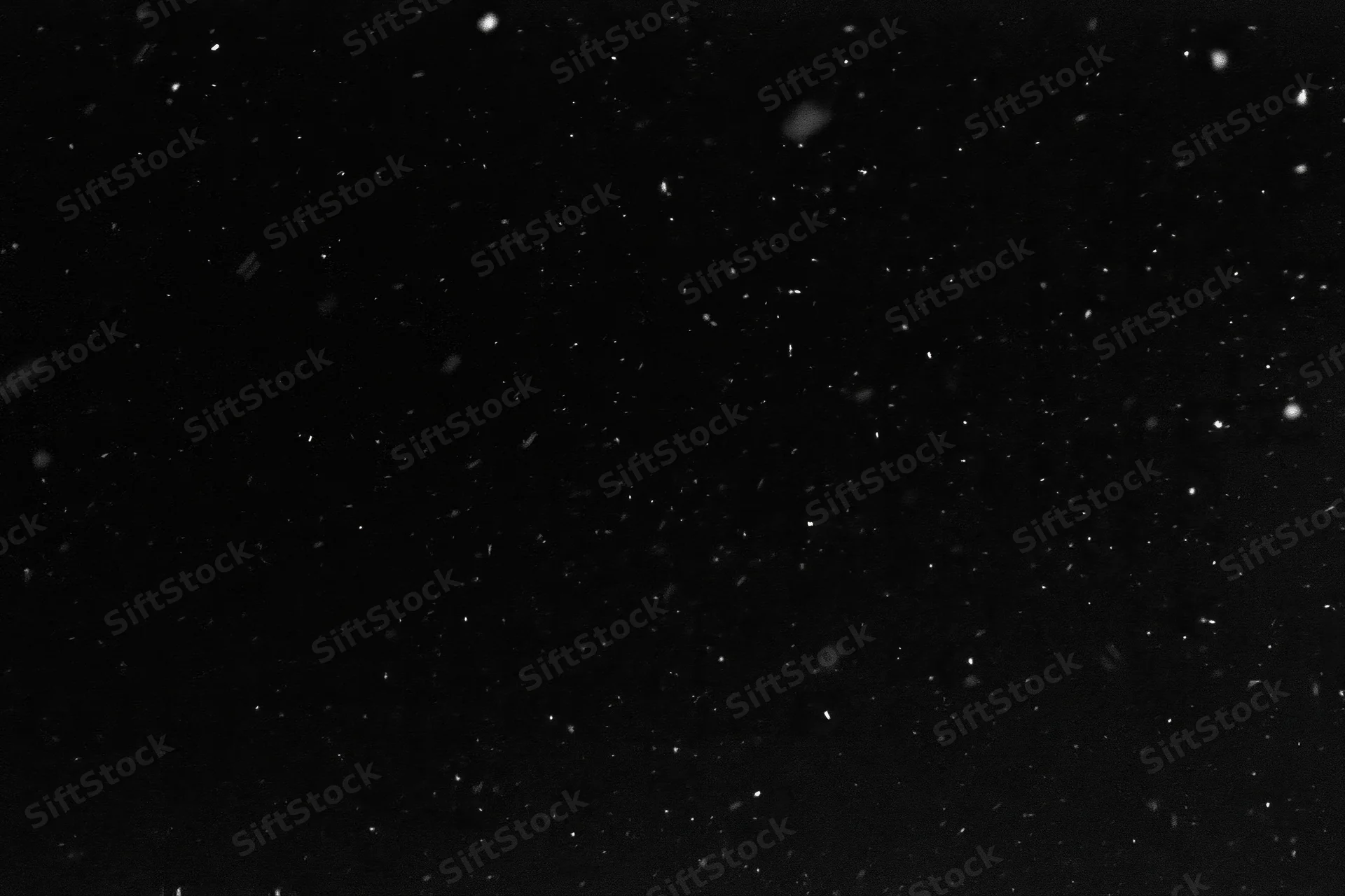 Snow falling against a pure black night sky