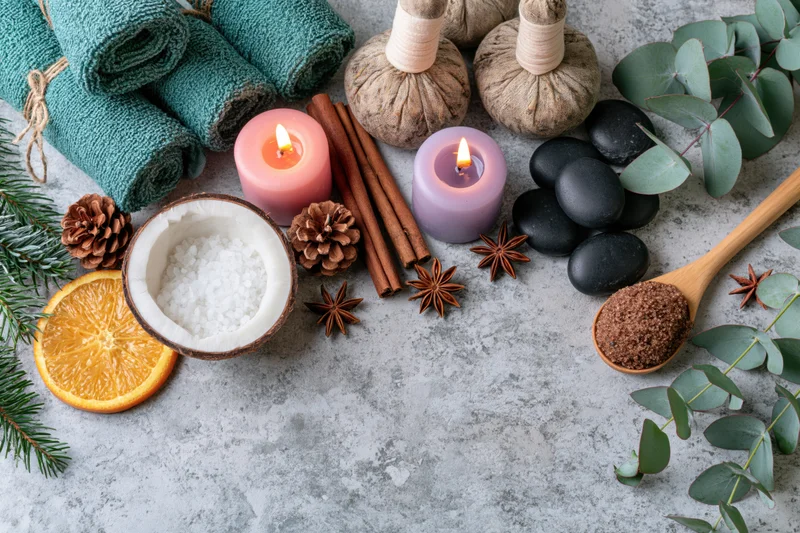 Spa wellness flat lay with candles, herbs, stones and citrus on textured grey concrete