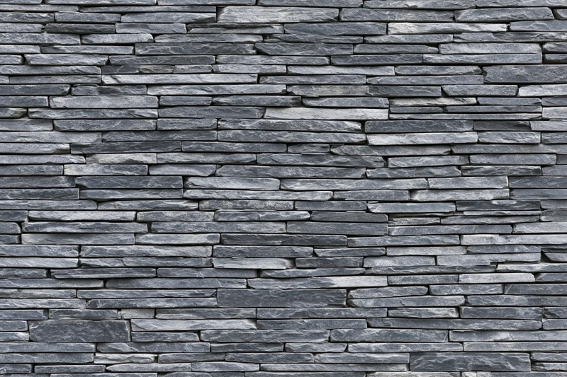 Stacked slate stone wall panel filling the frame with horizontal layers and gray texture