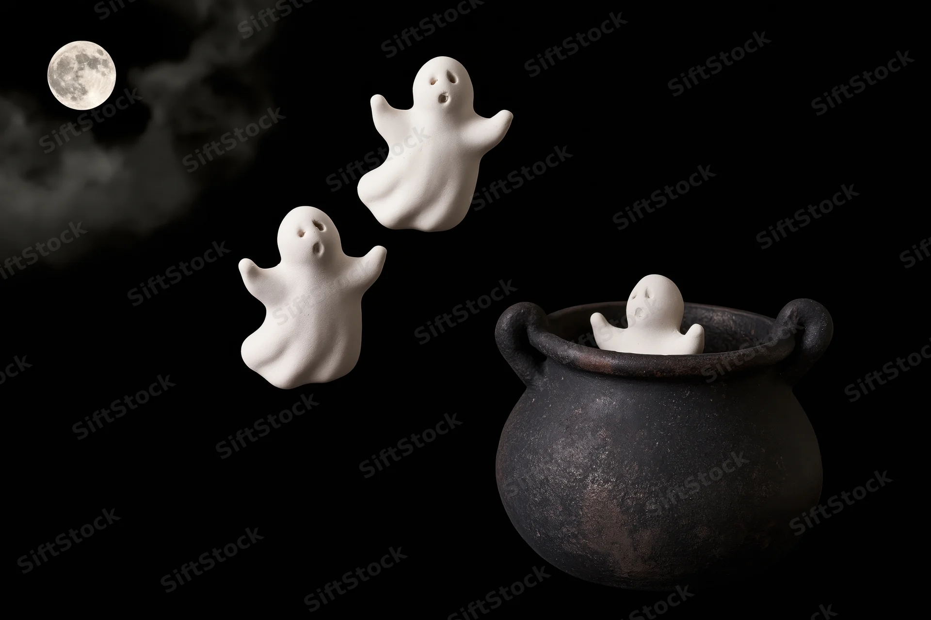 Three white ceramic ghost figurines floating near a black cauldron against a dark night sky with a full moon