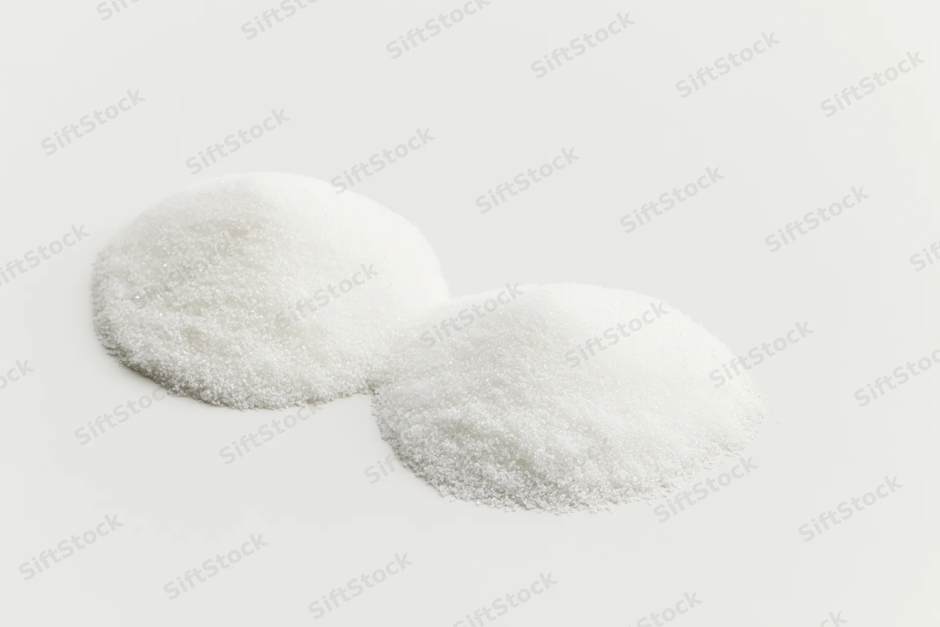 Two mounds of fine white crystalline powder on a plain white surface