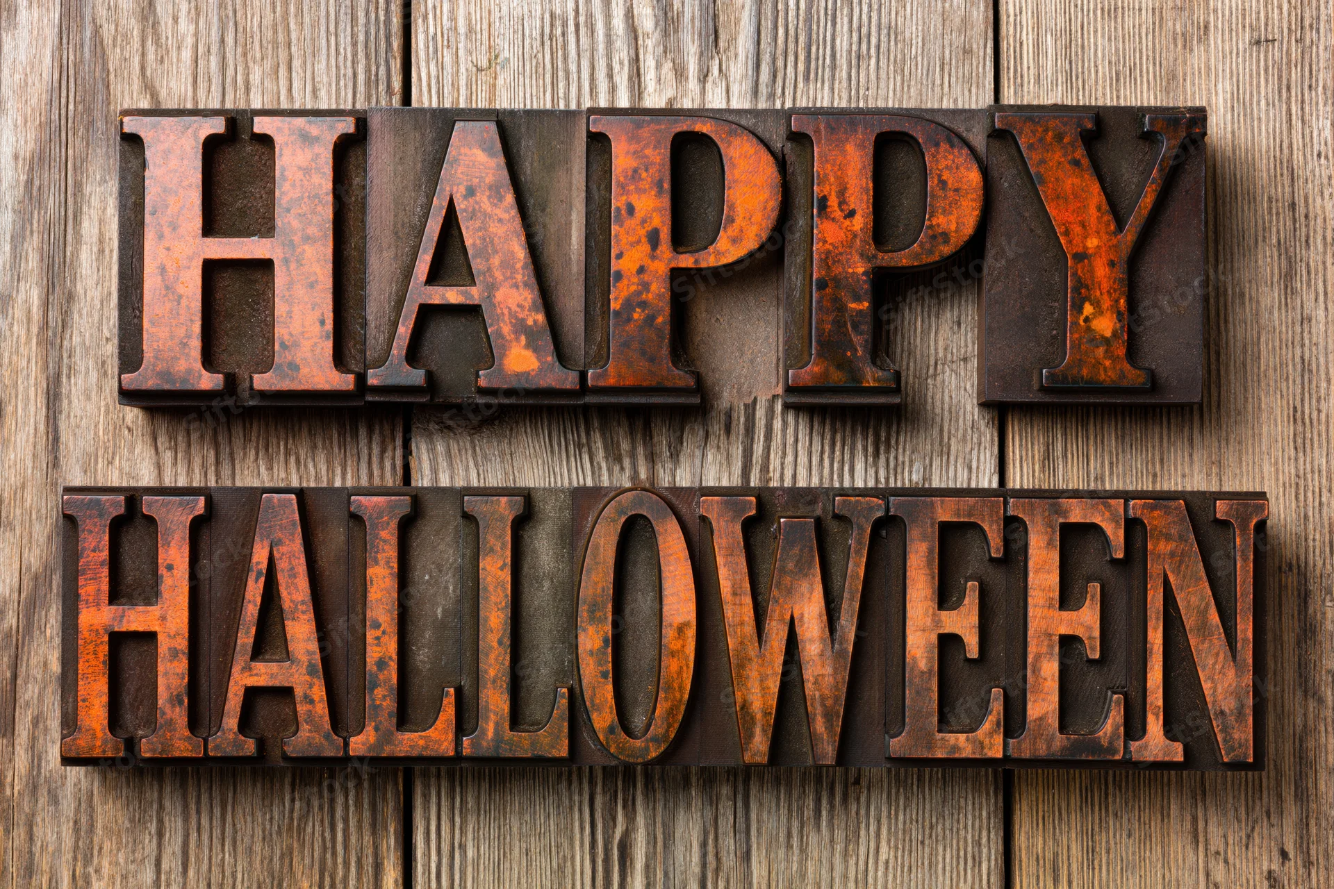 Vintage letterpress blocks spelling happy halloween on weathered wooden surface