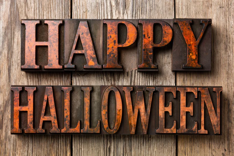 Vintage letterpress blocks spelling happy halloween on weathered wooden surface