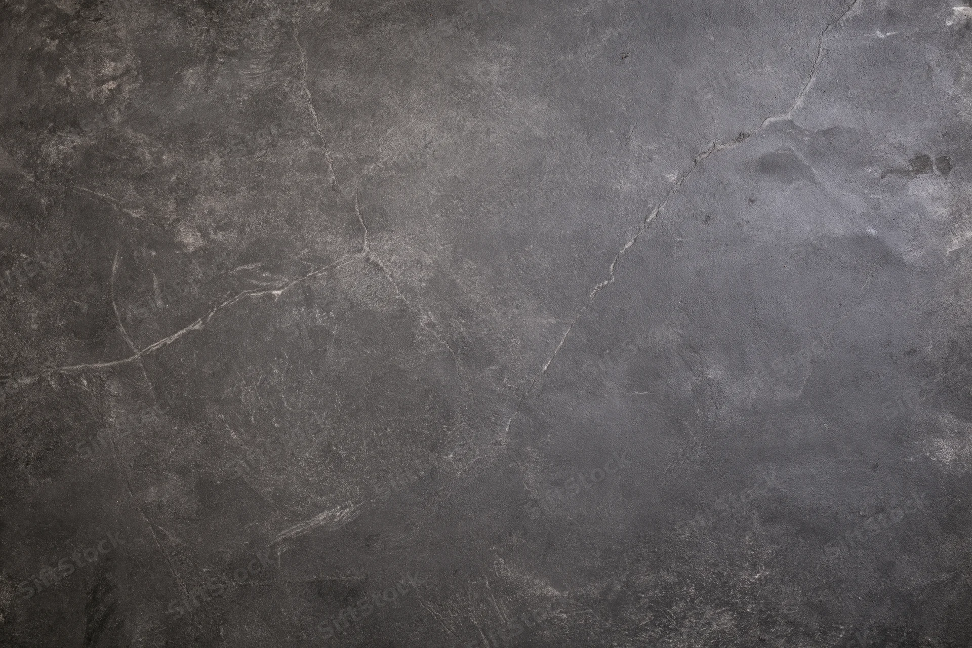 Weathered concrete wall surface filling the frame with cracks and texture