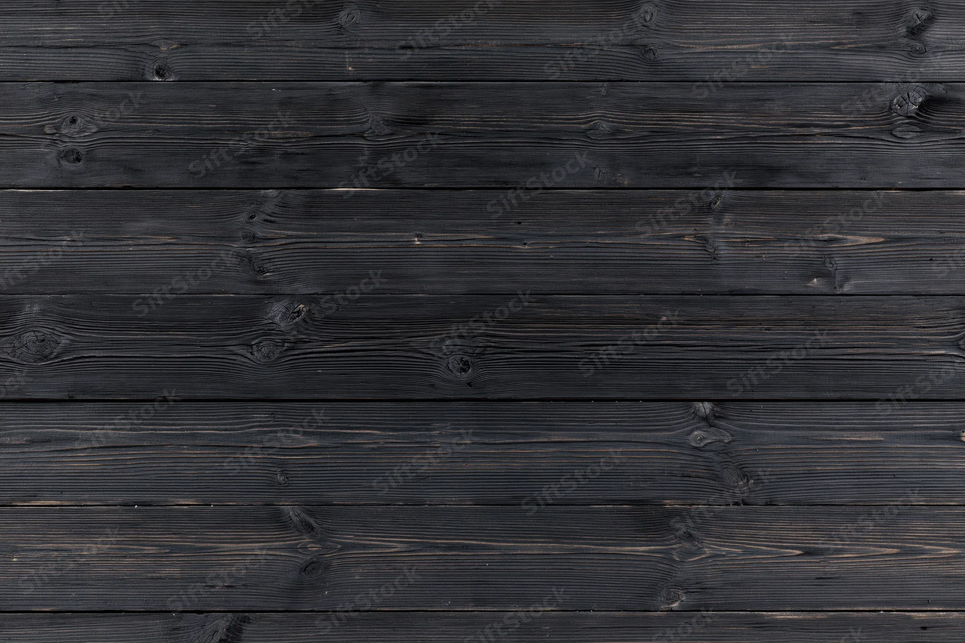 Horizontal dark charcoal weathered wooden planks forming a textured surface