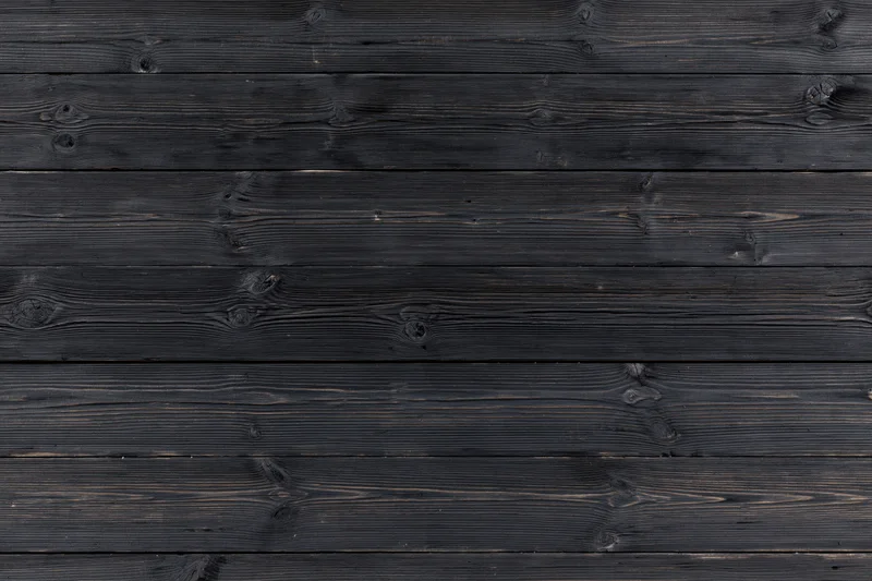 Horizontal dark charcoal weathered wooden planks forming a textured surface