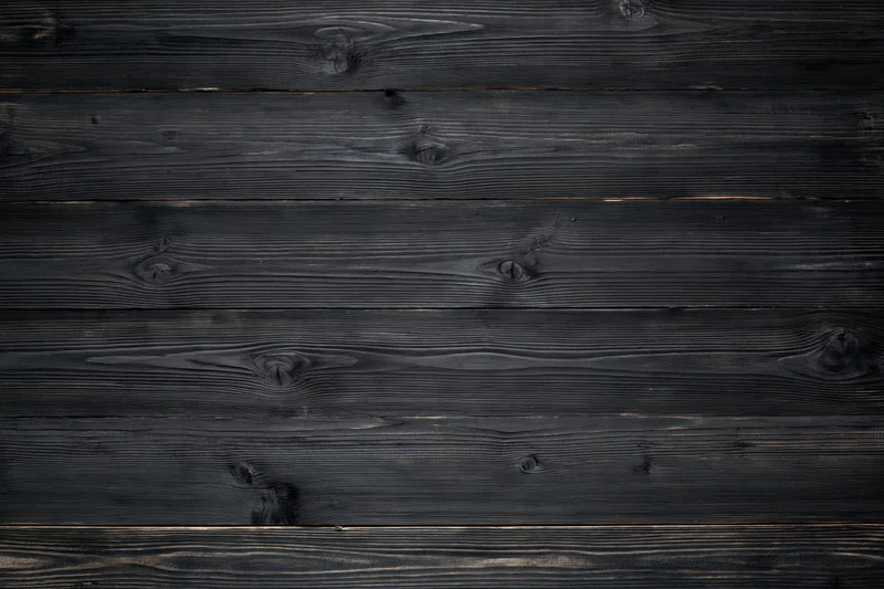 Horizontal dark charcoal weathered wooden planks forming a textured surface