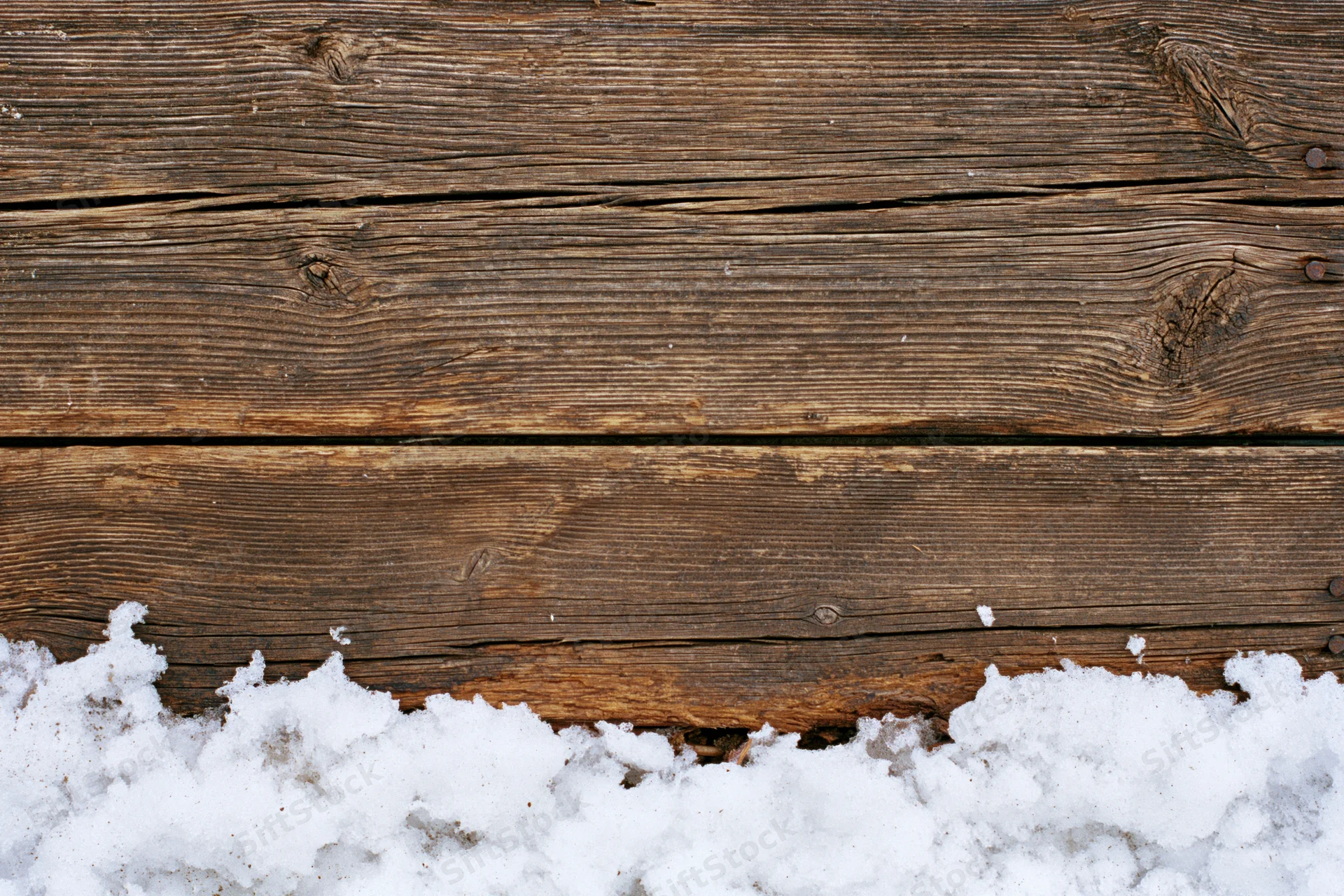 Weathered wooden planks with snow at the bottom, flat lay view