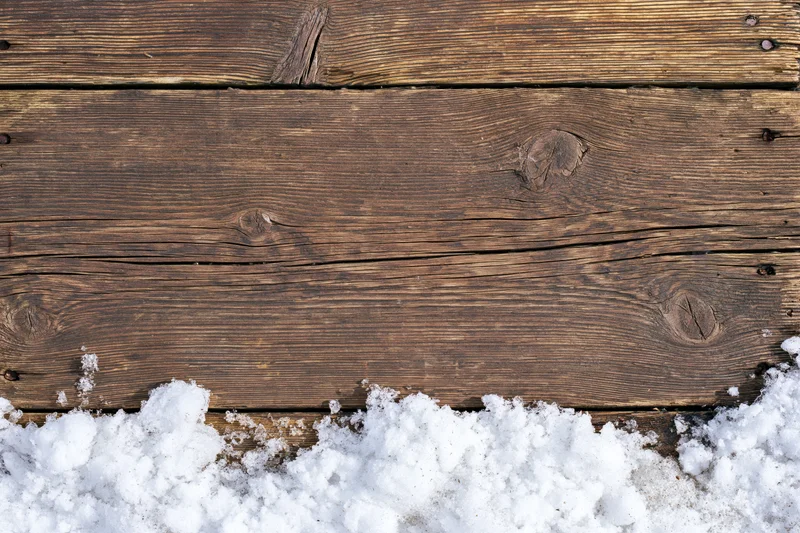 Weathered wooden planks with snow at the bottom, flat lay view